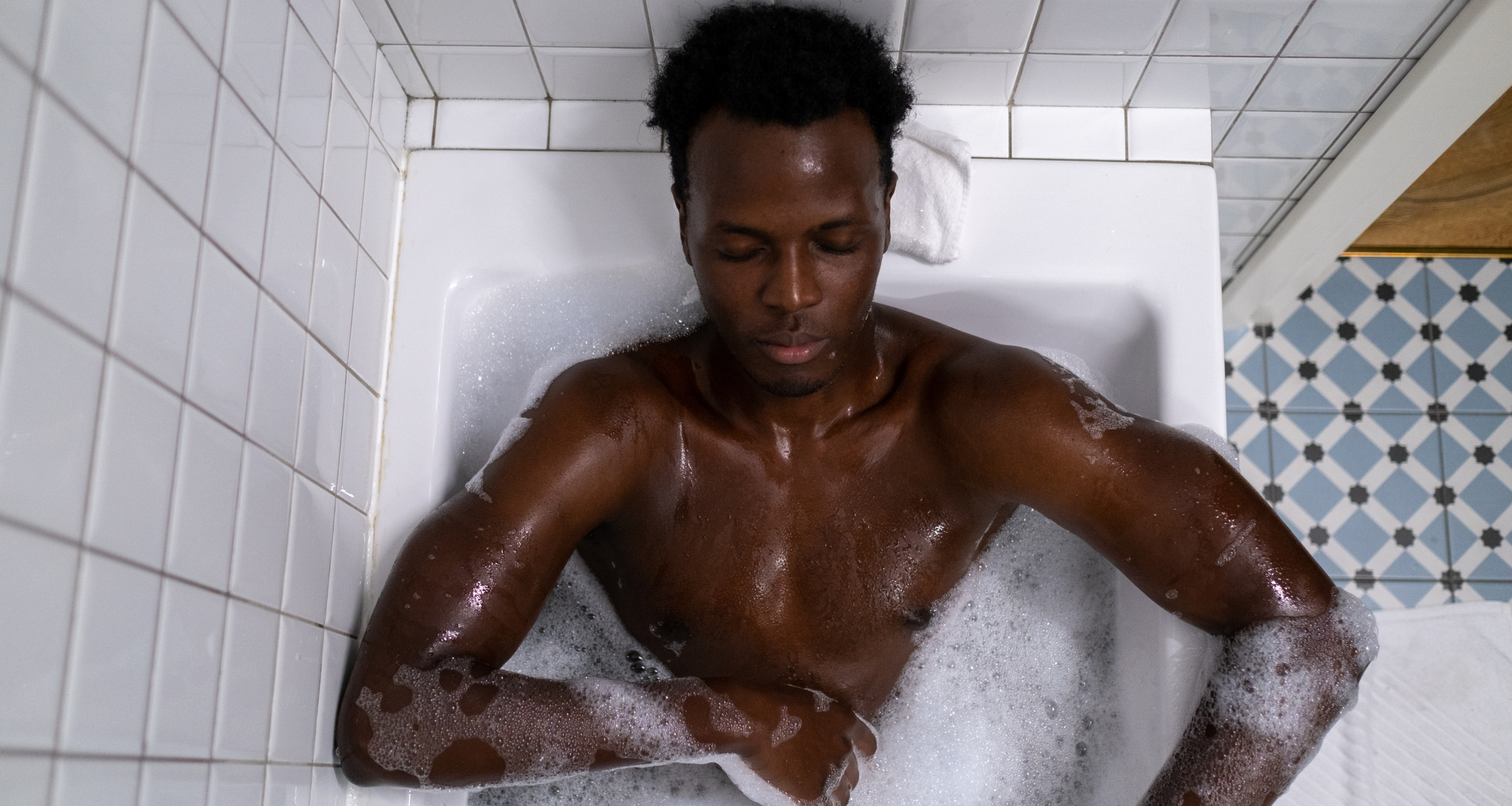 Homem na banheira com sabonete íntimo masculino